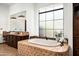 Elegant bathroom featuring a soaking tub, granite countertops, wood cabinets, and a frosted glass window at 11548 E Salero Dr, Scottsdale, AZ 85262
