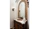 Powder room featuring custom vanity with vessel sink, mosaic backsplash, granite countertop and decorative sconces at 11548 E Salero Dr, Scottsdale, AZ 85262