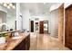 Expansive primary bathroom featuring a glass block wall, a soaking tub, dual vanities, and tiled floors at 11548 E Salero Dr, Scottsdale, AZ 85262