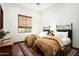 Comfortable bedroom featuring two twin beds, a hardwood floor, an oriental rug, and a large window at 11548 E Salero Dr, Scottsdale, AZ 85262