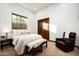 Cozy bedroom featuring neutral tones, a plush bed, an accent chair and ample natural light at 11548 E Salero Dr, Scottsdale, AZ 85262