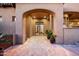 Charming front entrance with grand archway, potted plants, and brick pathway at 11548 E Salero Dr, Scottsdale, AZ 85262