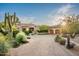 A stone home with a front yard featuring lush desert vegetation and a circular driveway at 11548 E Salero Dr, Scottsdale, AZ 85262