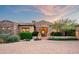 Inviting desert home with stone accents, arched doorway, and professionally landscaped grounds showcasing beauty and elegance at 11548 E Salero Dr, Scottsdale, AZ 85262