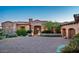 Charming desert home showcasing a stone facade, arched entrance, and mature landscaping for enhanced curb appeal at 11548 E Salero Dr, Scottsdale, AZ 85262