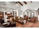 Expansive living room with a stone archway and elegant chandelier, open to kitchen and dining areas at 11548 E Salero Dr, Scottsdale, AZ 85262