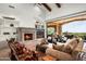 Living room offers a stone fireplace, beamed ceilings, built-in shelves, and access to the backyard at 11548 E Salero Dr, Scottsdale, AZ 85262