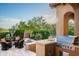 Outdoor kitchen with a built-in grill, a prep area, and seating around a cozy fire pit, perfect for entertaining at 11548 E Salero Dr, Scottsdale, AZ 85262