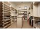 Walk-in closet with built-in shelving for shoes, clothes, and accessories, maximizing storage and organization at 11548 E Salero Dr, Scottsdale, AZ 85262