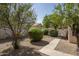 Backyard featuring gravel ground cover, mature landscaping, and a concrete walkway at 12044 S 45Th St, Phoenix, AZ 85044
