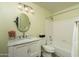 Bathroom features a single sink vanity with marble countertop, round mirror, and combination tub and shower at 12044 S 45Th St, Phoenix, AZ 85044