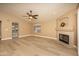 Bright living room features a fireplace, ceiling fan, and wood-look floors at 12044 S 45Th St, Phoenix, AZ 85044