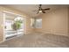 Light filled bedroom includes a ceiling fan, large window, and patio access at 12044 S 45Th St, Phoenix, AZ 85044