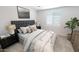 Bedroom with a gray headboard, neutral bedding, side tables and soft lamps at 12633 W Luxton Ln, Avondale, AZ 85323