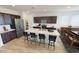 Kitchen with stainless steel appliances, island with barstools, dark cabinets and a pantry at 12633 W Luxton Ln, Avondale, AZ 85323