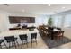Bright eat-in kitchen with white counters, dark cabinets, an island with bar seating, and a modern dining area at 12633 W Luxton Ln, Avondale, AZ 85323