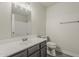 Bathroom features single sink vanity with grey cabinets, large mirror, and toilet at 15360 N 87Th Ave, Peoria, AZ 85381