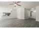 Open concept living area with ceiling fan and modern gray wood-look flooring at 15360 N 87Th Ave, Peoria, AZ 85381