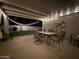 Outdoor covered back patio featuring a table and chairs, string lights, and view of the backyard at 1703 E Palo Blanco Way, Gilbert, AZ 85296