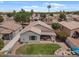 This backyard features a grassy area, a patio with an umbrella, and a pergola covered patio at 1703 E Palo Blanco Way, Gilbert, AZ 85296