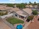 This backyard features a grassy area, a patio with an umbrella, and a pergola covered patio at 1703 E Palo Blanco Way, Gilbert, AZ 85296