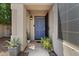 Charming entryway with a blue front door, desert landscaping, and a welcoming ambiance with potted plants at 1703 E Palo Blanco Way, Gilbert, AZ 85296