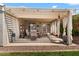 Covered patio with dining set, offering a relaxing outdoor space next to a lush landscape at 1703 E Palo Blanco Way, Gilbert, AZ 85296