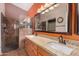 Bathroom with a double sink vanity, a large mirror, and a walk-in shower at 18080 W Spencer Dr, Surprise, AZ 85374