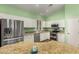 Bright kitchen features white cabinets, stainless steel appliances, and a large island with granite countertops at 18080 W Spencer Dr, Surprise, AZ 85374
