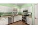 Updated kitchen features white cabinetry, stainless steel appliances, granite counters, and wood flooring at 18080 W Spencer Dr, Surprise, AZ 85374