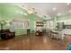 Bright living room featuring wood floors, plantation shutters, and a ceiling fan at 18080 W Spencer Dr, Surprise, AZ 85374