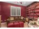 Well-lit living room features a comfortable couch, red ottomans, and unique bookshelf at 18080 W Spencer Dr, Surprise, AZ 85374