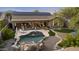 Beautiful backyard featuring a pool with rock waterfall, lounging area, and desert landscaping at 22205 W Ashleigh Marie Dr, Buckeye, AZ 85326
