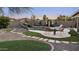 Beautiful backyard featuring a pool with a rock waterfall, patio, lounge chair, and manicured landscaping at 22205 W Ashleigh Marie Dr, Buckeye, AZ 85326