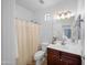 Traditional bathroom featuring a dark vanity, shower with curtain, and ample lighting, a functional space at 22205 W Ashleigh Marie Dr, Buckeye, AZ 85326