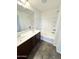 Bathroom featuring dual sinks, an oversized mirror, and a shower/tub with tiled surround at 2539 N 148Th Dr, Goodyear, AZ 85395