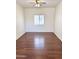 Vacant bedroom with window, ceiling fan, and wood-look flooring at 2539 N 148Th Dr, Goodyear, AZ 85395