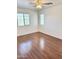 Bright bedroom featuring wood-look flooring, ceiling fan, and dual-pane windows with stylish blinds at 2539 N 148Th Dr, Goodyear, AZ 85395
