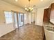 Dining space with tiled flooring, modern chandelier, and sliding glass door access to backyard at 2539 N 148Th Dr, Goodyear, AZ 85395