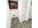 Laundry room featuring dark wood cabinets, tile flooring and a utility closet at 2539 N 148Th Dr, Goodyear, AZ 85395