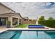 Beautiful backyard with a sparkling pool, a blue lounge, and lush green landscaping at 2854 E Virginia St, Mesa, AZ 85213