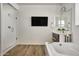 Bright bathroom with a soaking tub, walk-in shower, wood-look tile floor and a wall-mounted TV at 2854 E Virginia St, Mesa, AZ 85213