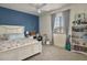 Bright bedroom with a blue accent wall, decorative shelving and a ceiling fan at 2854 E Virginia St, Mesa, AZ 85213