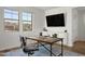 Bright office featuring a rustic desk, comfortable chair, and a view of the neighborhood through large windows at 2854 E Virginia St, Mesa, AZ 85213