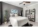 Bedroom features a ceiling fan, gray accent wall, and a white bed with decorative pillows at 29606 N Tatum Blvd # 245, Cave Creek, AZ 85331