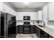 Well-equipped kitchen with granite countertops, white cabinets, and sleek black appliances at 29606 N Tatum Blvd # 245, Cave Creek, AZ 85331
