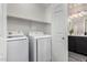 An interior laundry room showcasing a side by side washer and dryer with a shelf above at 29606 N Tatum Blvd # 245, Cave Creek, AZ 85331
