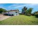 Large backyard with block fencing, grass, mature landscaping and partial covered patio at 35 E Secretariat Dr, Tempe, AZ 85284