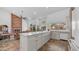 Open kitchen with granite island, white cabinetry, stainless appliances, and brick fireplace adjacent to the living area at 35 E Secretariat Dr, Tempe, AZ 85284