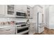 Modern kitchen with white cabinetry, marble countertop, stainless steel appliances, and glass-front cabinets at 35 E Secretariat Dr, Tempe, AZ 85284